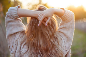 Young blonde woman standing outside in the early evening